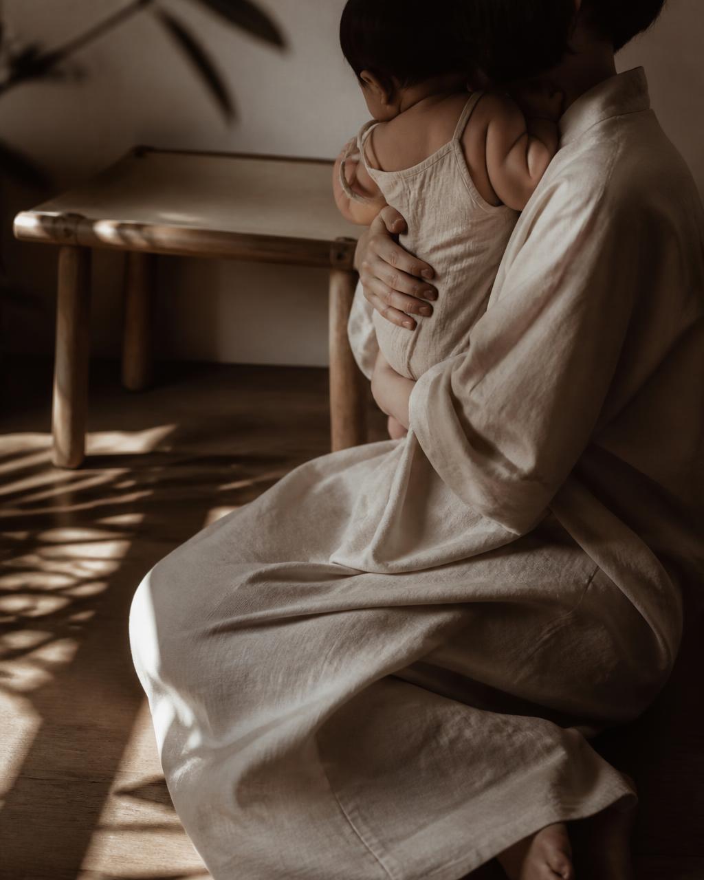A parent holding a baby close